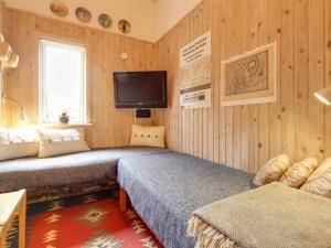 - une chambre avec 2 lits et une télévision murale dans l'établissement Holiday Home Erja - 150m from the sea in NE Jutland by Interhome, à Hals