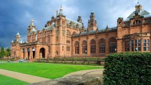 a large building with a green lawn in front of it at Royal West End Hotel in Glasgow