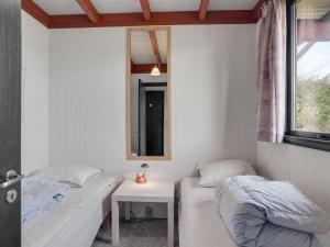 um quarto com 2 camas, uma mesa e um espelho em Holiday Home Polina - 800m from the sea in NE Jutland by Interhome em Hals