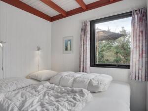 1 dormitorio con 1 cama y una ventana con sombrilla en Holiday Home Polina - 800m from the sea in NE Jutland by Interhome, en Hals