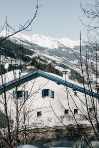 a building with a snow covered mountain in the background at Charming chalet with sauna + views! in Bad Gastein
