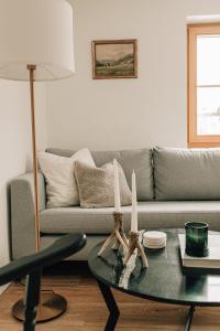 uma sala de estar com um sofá e uma mesa com velas em Charming chalet with sauna + views! em Bad Gastein