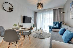 - un salon avec un canapé et une table dans l'établissement Comfort Apartments Kopernika, à Gdynia