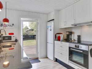 a kitchen with white appliances and a door to a yard at Holiday Home Sybille - from the sea in NE Jutland by Interhome in Hals