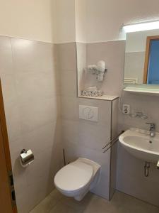 ein kleines Bad mit WC und Waschbecken in der Unterkunft Hotel Pension Neptun in Ückeritz