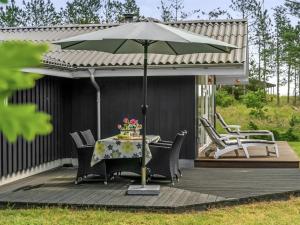 un patio con mesa y sombrilla en Holiday Home Ajten - 150m from the sea in NE Jutland by Interhome, en Saeby