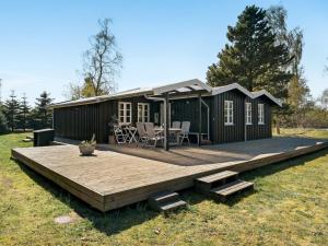 una casa pequeña con terraza y mesa en Holiday Home Blandina - 300m to the inlet in NE Jutland by Interhome en Storvorde