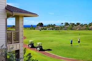 two people playing golf on a golf course at Pili Mai 6K in Koloa