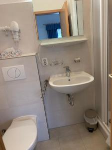 W łazience znajduje się umywalka, toaleta i lustro. w obiekcie Hotel Pension Neptun w mieście Ückeritz