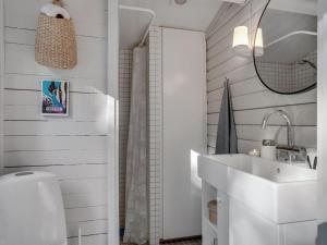 uma casa de banho branca com um lavatório e um espelho em Holiday Home Susannah - from the sea in NE Jutland by Interhome em Hals