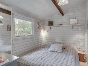 um pequeno quarto com uma cama e uma janela em Holiday Home Susannah - from the sea in NE Jutland by Interhome em Hals