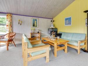 ein Wohnzimmer mit einem Sofa und einem Tisch in der Unterkunft Holiday Home Anniesette - 1km from the sea in NE Jutland by Interhome in Hals