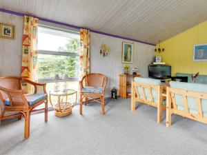 ein Wohnzimmer mit Stühlen, einem Tisch und einem TV in der Unterkunft Holiday Home Anniesette - 1km from the sea in NE Jutland by Interhome in Hals