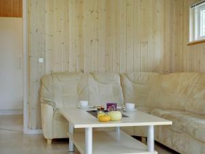 ein Wohnzimmer mit einem Sofa und einem Couchtisch in der Unterkunft Holiday Home Thorketil - 1-1km from the sea in NE Jutland by Interhome in Hals