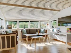 uma sala de estar com um sofá e uma mesa em Holiday Home Erhardt - 800m from the sea in NE Jutland by Interhome em Hals