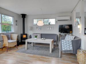 ein Wohnzimmer mit einem Sofa, einem Tisch und einem TV in der Unterkunft Holiday Home Kajo - 800m from the sea in NE Jutland by Interhome in Hals