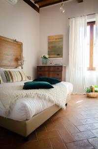 ein Schlafzimmer mit einem großen Bett und einem Fenster in der Unterkunft Dimora Dell'Erbe Rooms in Montepulciano