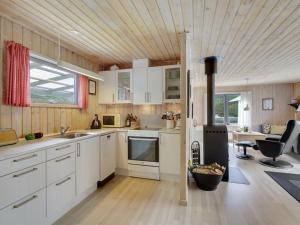 cocina con armarios blancos y techo de madera en Holiday Home Ane - 1-7km from the sea in NE Jutland by Interhome, en Hals