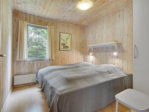 1 dormitorio con 1 cama grande en una habitación de madera en Holiday Home Ane - 1-7km from the sea in NE Jutland by Interhome, en Hals