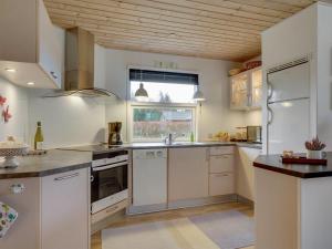 een grote keuken met witte apparatuur en een raam bij Holiday Home Nico - 1-1km from the sea in NE Jutland by Interhome in Hals