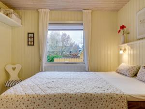 een slaapkamer met een bed en een raam bij Holiday Home Nico - 1-1km from the sea in NE Jutland by Interhome in Hals