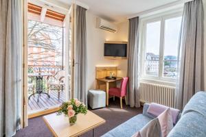 a living room with a couch and a table and a window at Apartment Hotel Schreier in Lindau