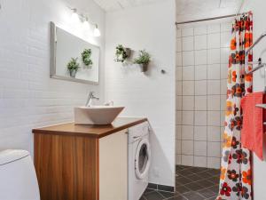 y baño con lavabo y lavadora. en Apartment Amaryllis - 100m from the sea in NE Jutland by Interhome en Hals