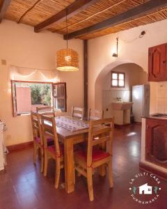 uma sala de jantar com uma mesa de madeira e cadeiras em La Vilti casa de Purmamarca em Purmamarca