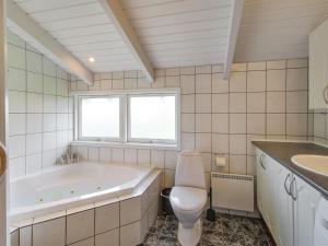 een badkamer met een bad, een toilet en een wastafel bij Holiday Home Clari - 500m from the sea in NE Jutland by Interhome in Hals