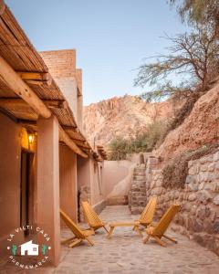 - un ensemble de chaises assises sur une terrasse dans l'établissement La Vilti casa de Purmamarca, à Purmamarca