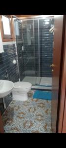 a bathroom with a toilet and a glass shower at Chalet Impero in Scauri