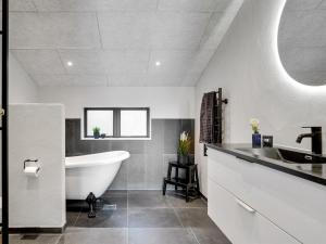 a bathroom with a white tub and a sink at Holiday Home Sinna - from the sea in NE Jutland by Interhome in Hals