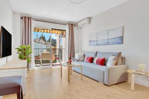 een woonkamer met een bank en een tafel bij Paloma's Cozy Beach Flat in Torremolinos