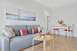 een woonkamer met een bank en een tafel bij Paloma's Cozy Beach Flat in Torremolinos