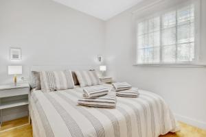 een witte slaapkamer met een bed met 2 kussens erop bij Paloma's Cozy Beach Flat in Torremolinos +17 foto's