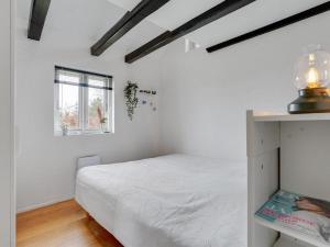a bedroom with a white bed and a window at Holiday Home Edith - 1km from the sea by Interhome in Hals