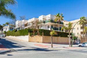 een gebouw met palmbomen voor een straat bij Paloma's Cozy Beach Flat in Torremolinos
