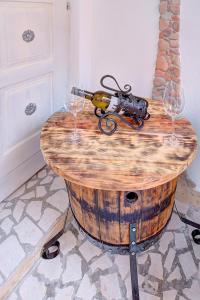 a wine bottle and two wine glasses sitting on a barrel at Apartmani Frankopan in Senj