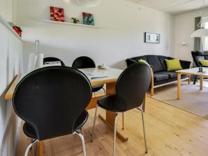 - un salon avec des chaises noires et une table dans l'établissement Apartment Osfrid - 100m from the sea in NE Jutland by Interhome, à Hals