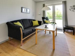 sala de estar con sofá negro y mesa en Apartment Osfrid - 100m from the sea in NE Jutland by Interhome, en Hals