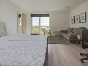 um quarto com uma grande cama branca e um sofá em Holiday Home Helja - 125m from the sea in NE Jutland by Interhome em Hals