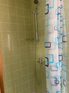 a shower with a white and blue shower curtain at Hotel Maien in Todtmoos