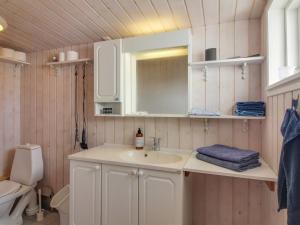 a bathroom with a sink and a toilet at Holiday Home Adi - 75m from the sea in NW Jutland by Interhome in Løkken