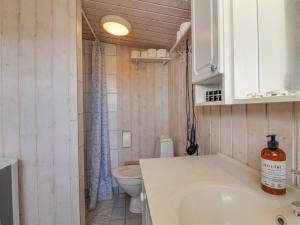 a small bathroom with a sink and a toilet at Holiday Home Adi - 75m from the sea in NW Jutland by Interhome in Løkken