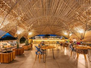 a restaurant with tables and chairs and a large ceiling at Bamboo Zanzibar in Jambiani