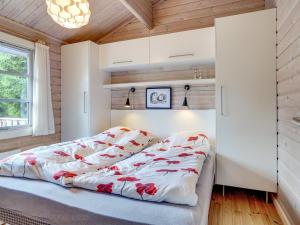 um quarto com uma cama com lençóis vermelhos e brancos em Holiday Home Uuno - 1-2km from the sea in NE Jutland by Interhome em Hadsund