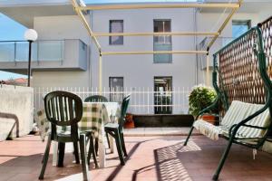 een patio met een tafel en stoelen en een gebouw bij Terrazza a pochi passi dal mare in Loano