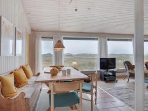 Holiday Home Eri - 300m from the sea in NW Jutland by Interhome في Pandrup: غرفة معيشة مع طاولة وأريكة