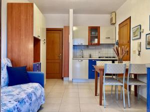 een woonkamer met een tafel en een keuken bij Terrazza a pochi passi dal mare in Loano