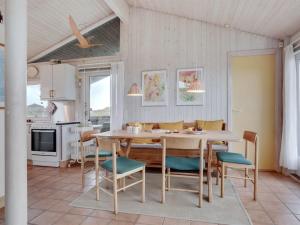 Holiday Home Eri - 300m from the sea in NW Jutland by Interhome في Pandrup: مطبخ وغرفة طعام مع طاولة وكراسي